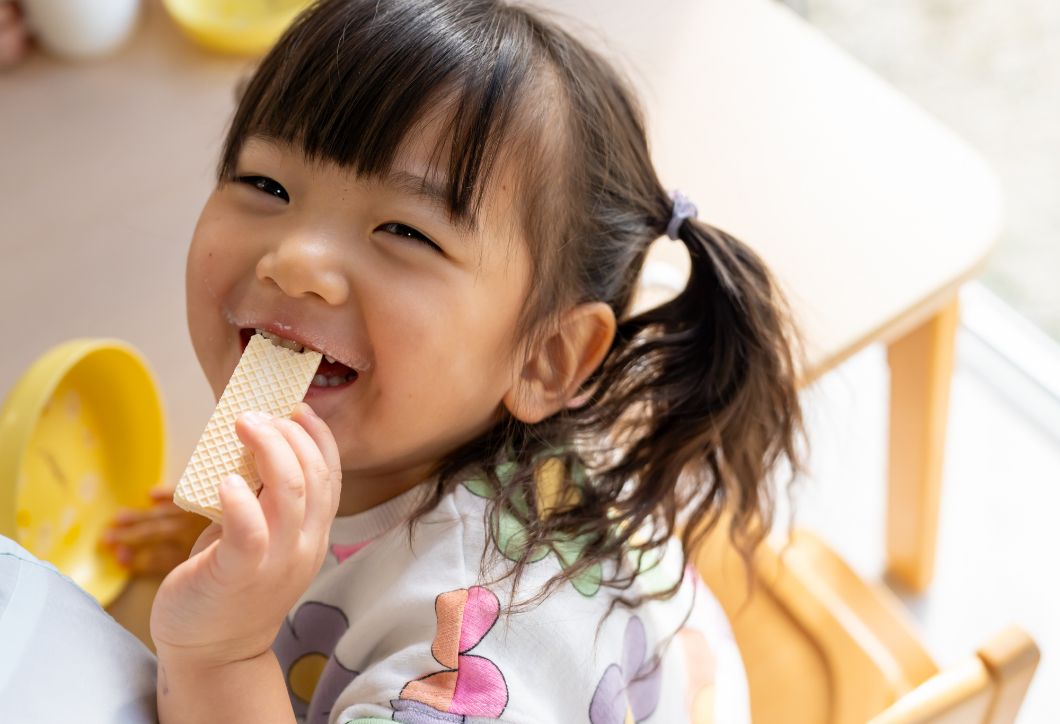 お菓子を食べる園児の画像